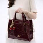 COACH SIGNATURE PATENT MINI TOTE BAG WITH CHERRY CHARM - Image 2